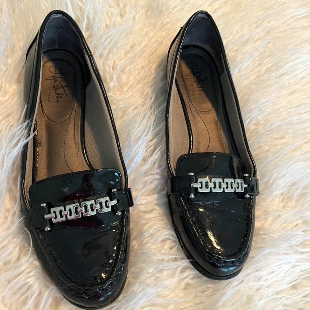 Black patent leather slip-ons with sliver front buckle
